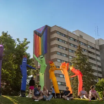 Rainbow inflatable people at Cook Out event in housing 